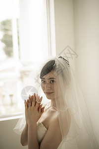 穿着婚纱戴着头纱激动的新娘图片