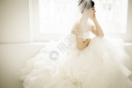 头戴头纱穿着婚纱沉思的新娘图片