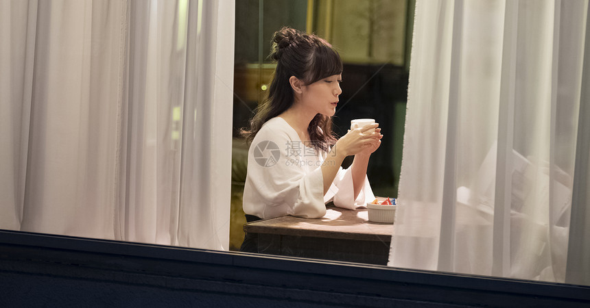 一个女人在一家咖啡馆享受咖啡图片