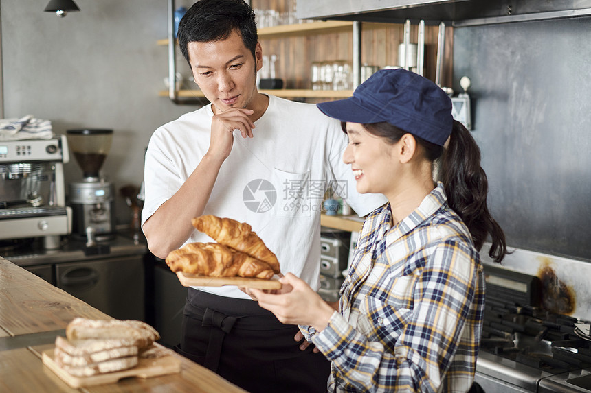 咖啡店里的店员端着面包食物图片