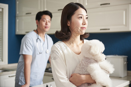 女子抱着宠物狗去看兽医图片