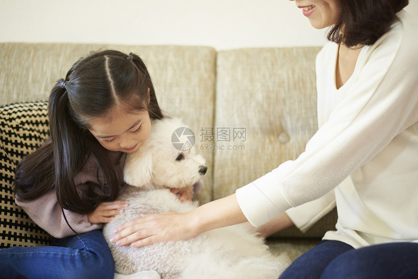 妈妈和女儿一起陪宠物狗玩耍图片