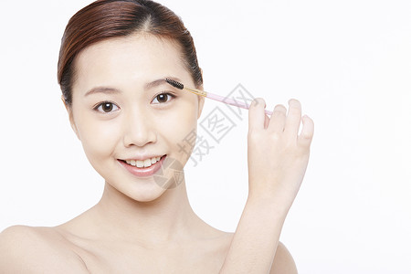眉毛透明素材使用眉刷的年轻女子背景