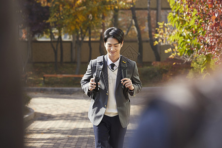 背着书包上学的男女高中生背景图片