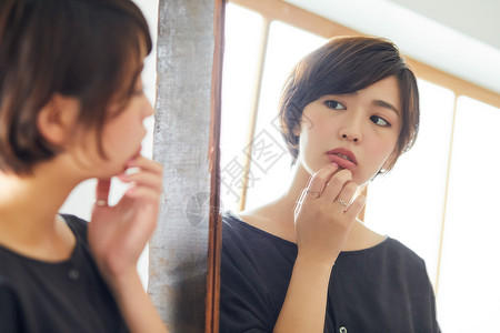 窗边的年轻女人照镜子图片