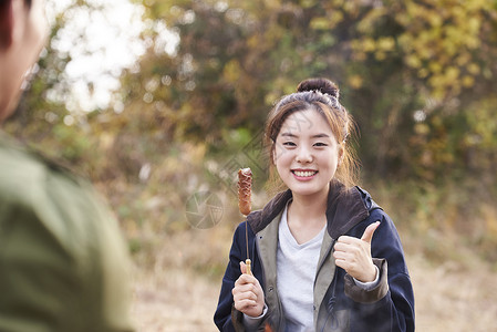 女子享受露营烧烤图片