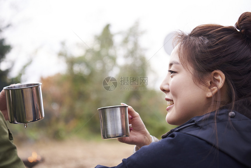 野外露营的年轻女人喝咖啡图片