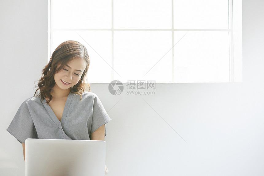 室内快乐的女人正看着笔记本电脑图片
