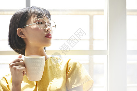 女人在窗边放松喝茶图片