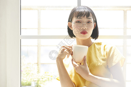 白天女人窗边休息喝茶图片