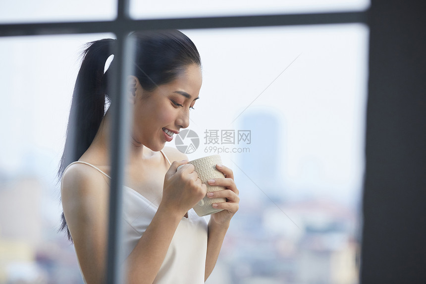 户外阳台捧着咖啡的女青年图片