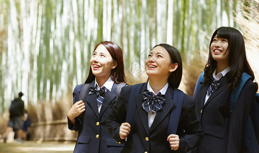 丛林里的女孩三名高中女孩在竹林里游玩背景