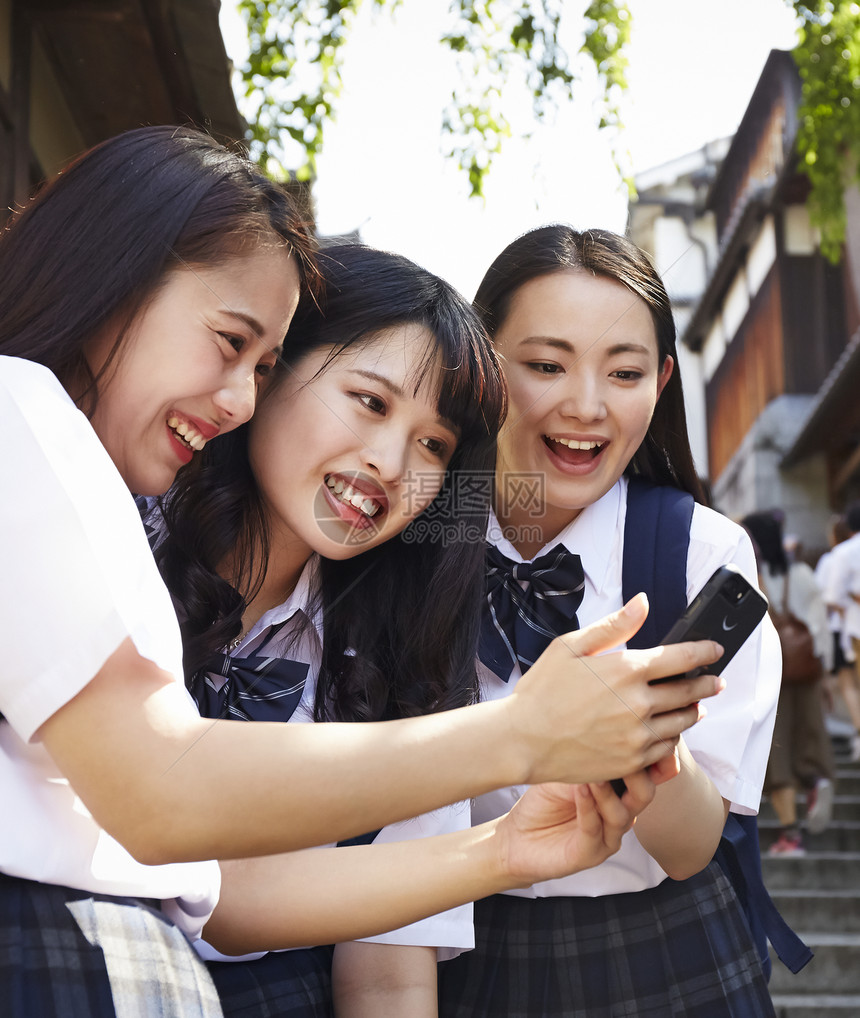 三个背包高中女孩在景点游玩图片