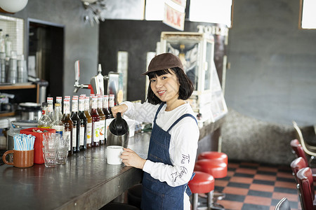 日本人女孩喝在一家咖啡馆工作的妇女图片