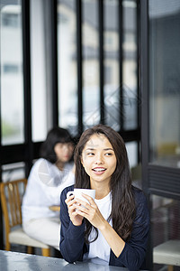 餐厅里喝茶的年轻女人图片