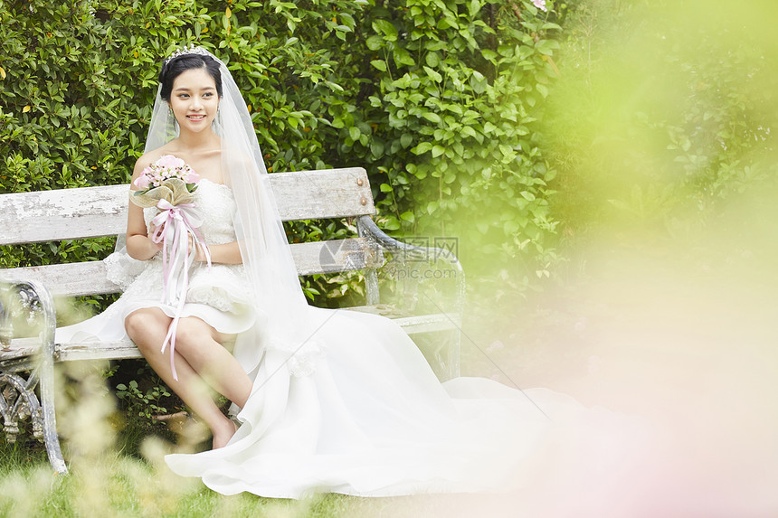 坐在长凳上手拿捧花的新娘图片