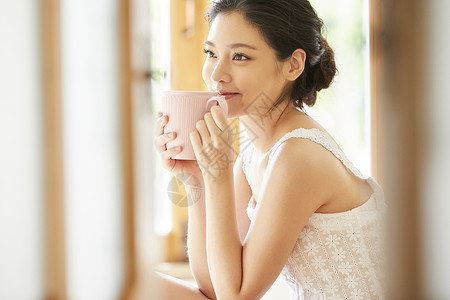 喝热茶居家捧着咖啡的年轻女子背景