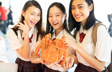 抓螃蟹的女孩女高中生手拿海鲜背景