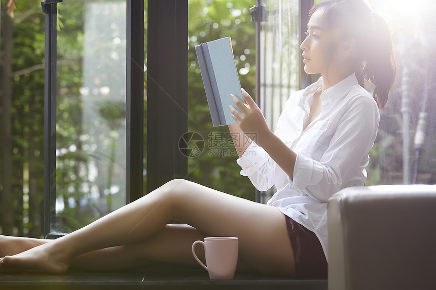 自然窗户的女人放松看书图片