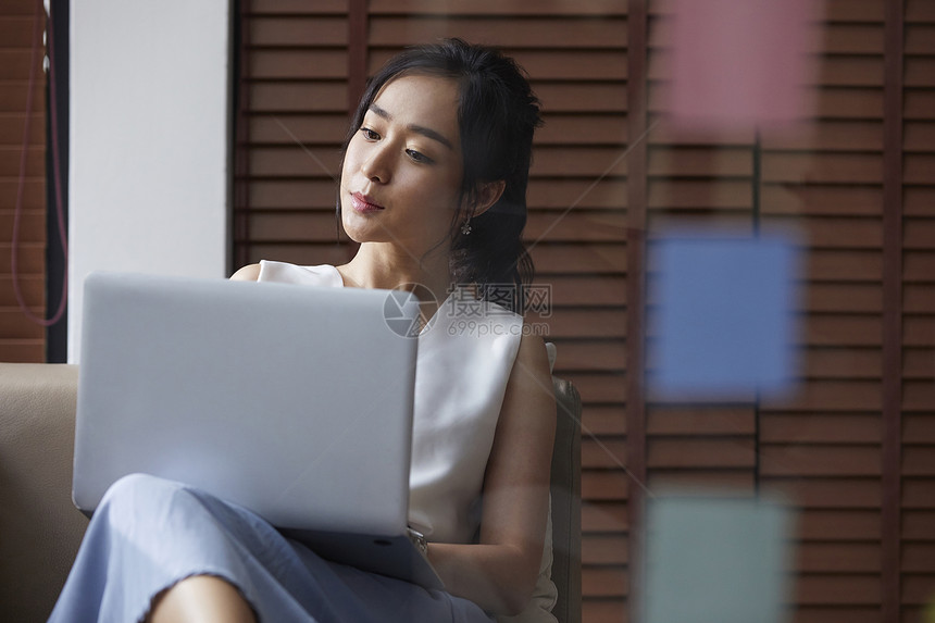 坐在沙发上的职业女性看电脑图片