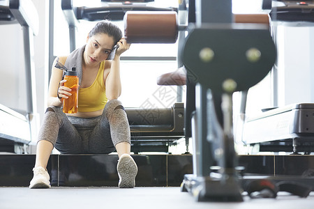 坐着擦汗休息的运动女性图片