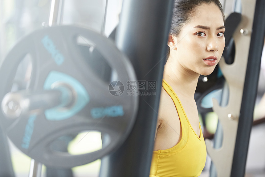 健身房举起杠铃锻炼健身的女青年图片