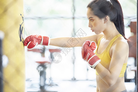 戴着拳套练习拳击的运动女青年图片