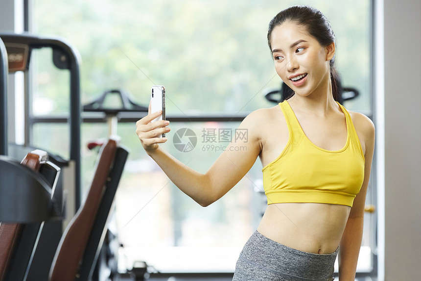 健身房拿着手机自拍的女青年图片