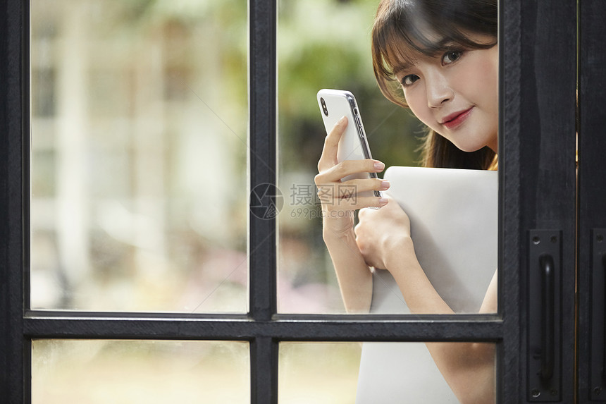 拿着笔记本电脑和手机的青年女性图片