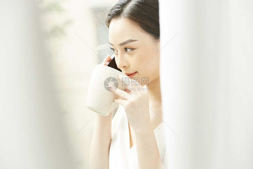 接听电话喝咖啡的年轻女子图片