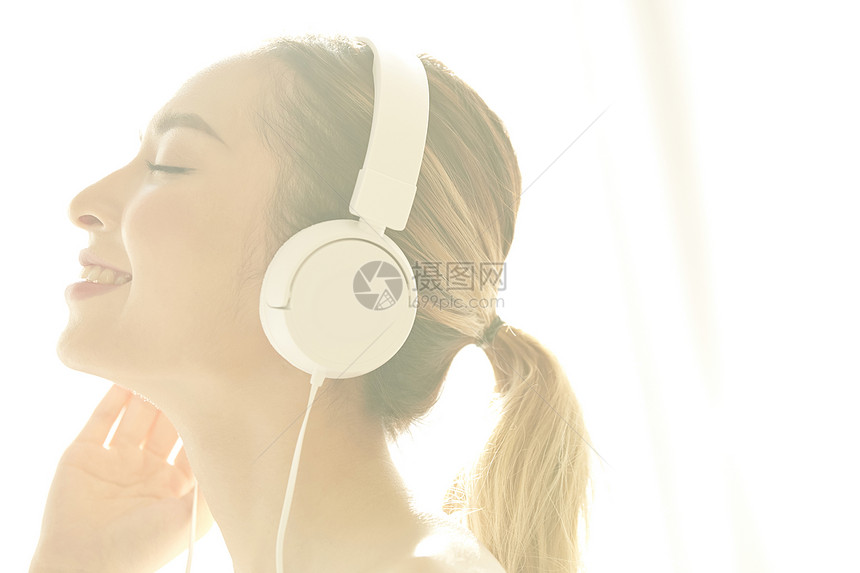 戴着耳机听音乐放松的年轻女子图片