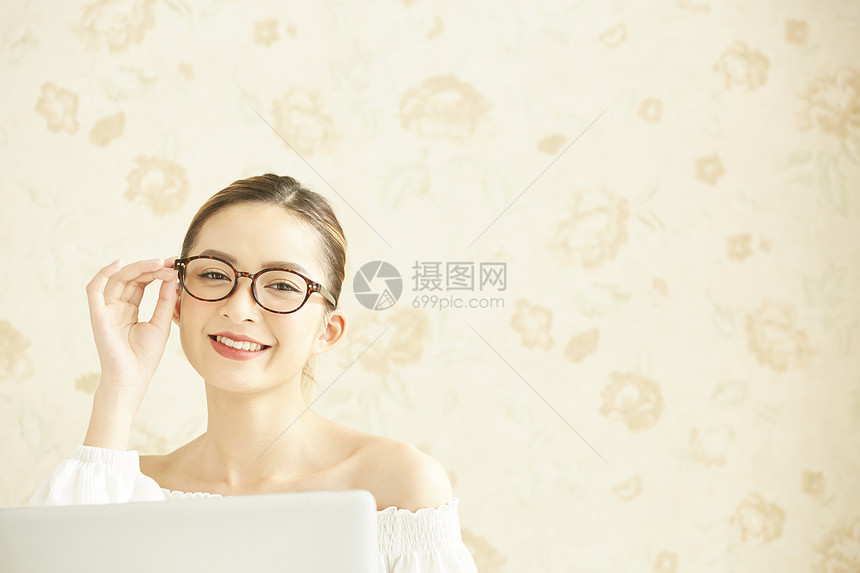 扶眼镜微笑的年轻女子图片