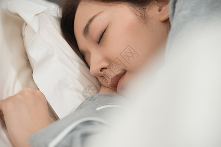 躺在床上睡觉的居家女性背景图片