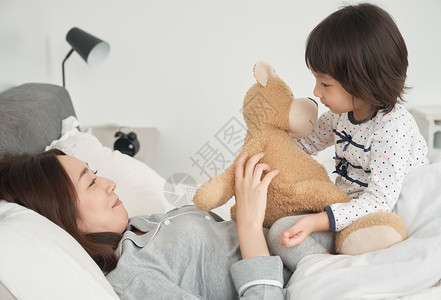 女儿贪玩肖像父母和孩子在床上玩图片