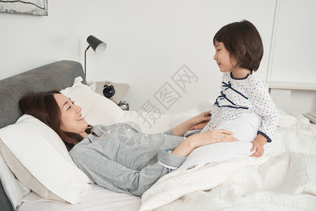 时髦睡着生活父母和孩子在床上玩图片
