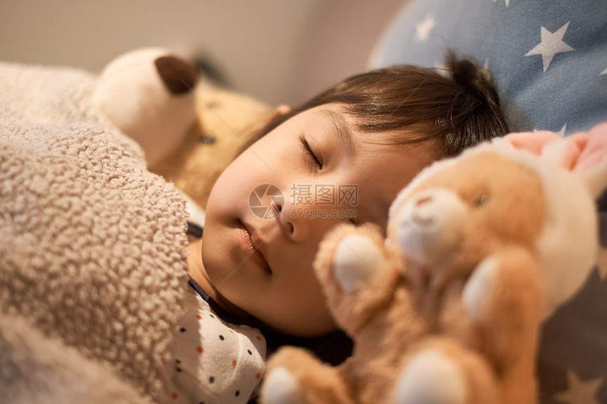 年轻的女孩睡在床上的孩子图片