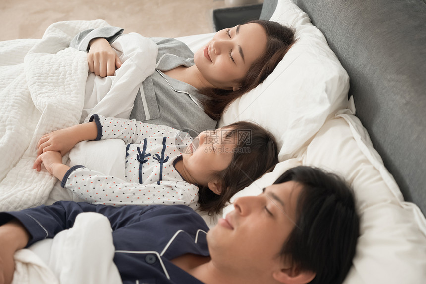 亚洲人家庭亚洲父母和孩子睡在床上图片