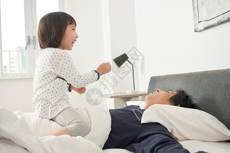 能源30多岁留白父母和孩子在床上玩图片