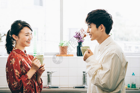 帅好朋友对话男和女与一个杯子聊天在厨房里图片