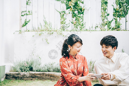 周末帅哥茶点拍摄照片的男人和妇女当野餐在庭院里时图片