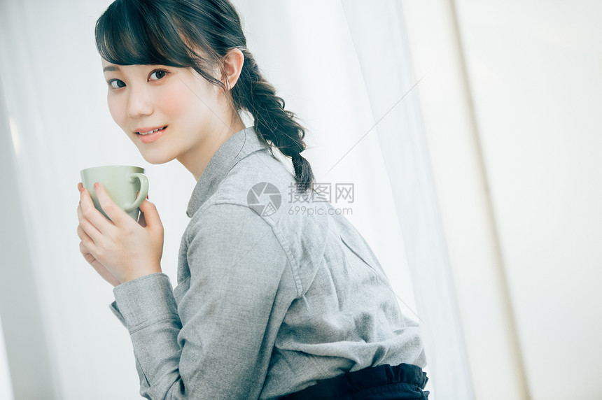 穿灰色衬衫的女孩喝咖啡图片