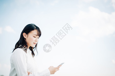 女青年站立在屋顶上看手机图片