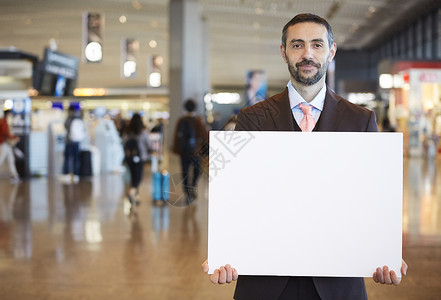 男子商务人士工作在海外商务旅行的一个商人消息在机场图片