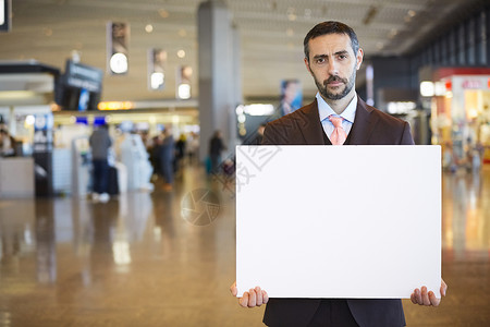 室内持有商业在海外商务旅行的一个商人消息在机场图片