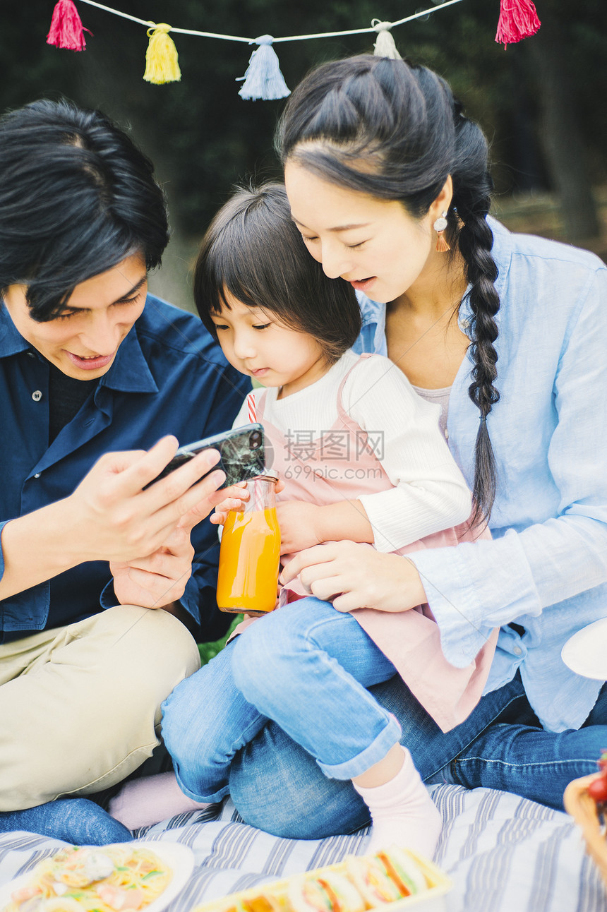 户外一家人在草地上露营吃饭图片