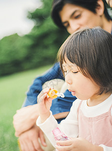 户外一家人在草地上露营吃饭高清图片