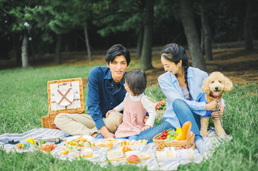 户外一家人在草地上露营吃饭图片
