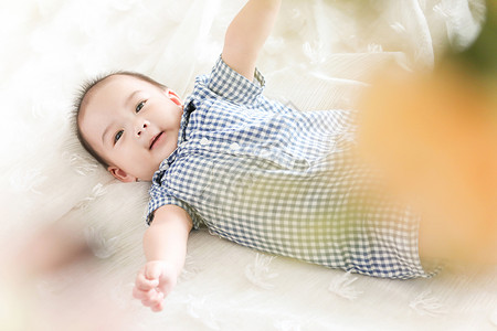 床上张开双臂微笑的可爱婴儿图片