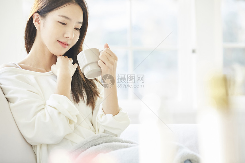 女人端着水杯喝水图片