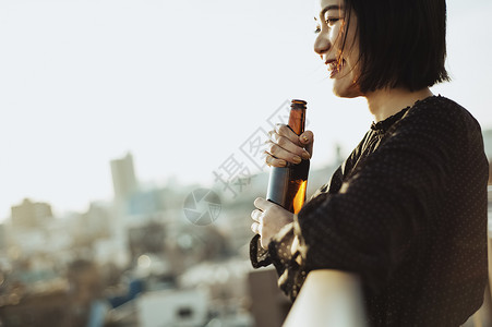 屋顶喝酒的女性图片